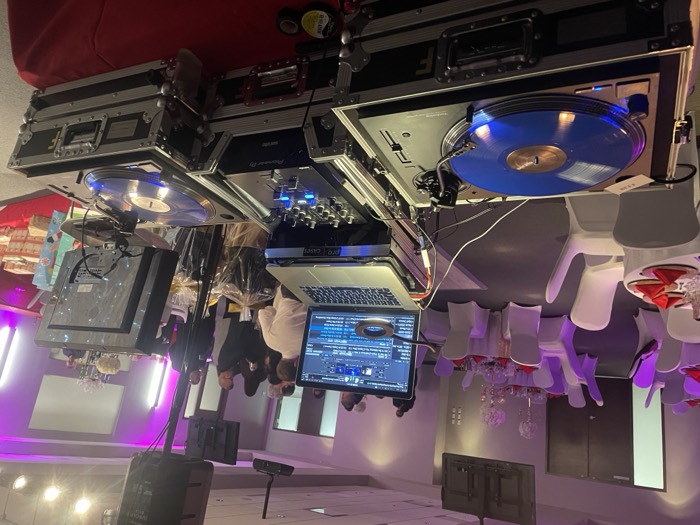 DJ booth at a wedding reception with guests in the background